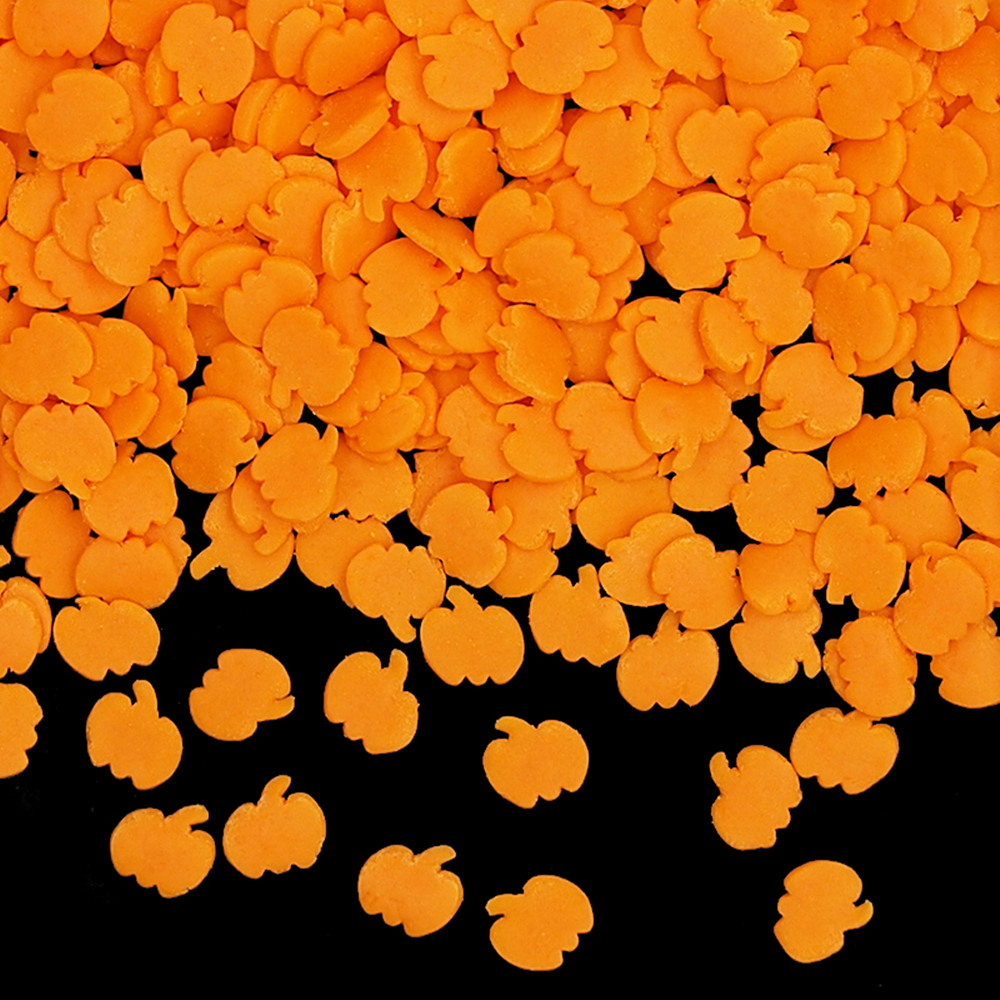 Bulk solid natural orange pumpkin-shaped sprinkles for industrial Halloween bakery production.